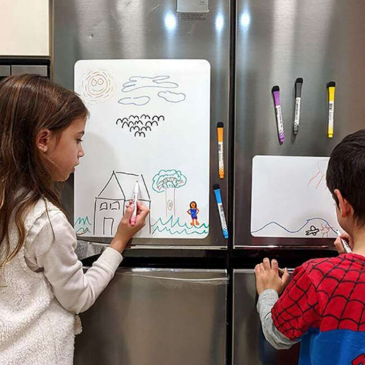 White magnetic erasable message board with colorful marker drawings, two people using it