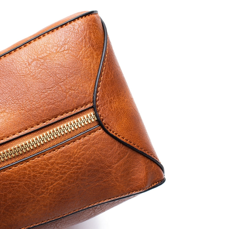 Brown leather tote bag side close-up with stitched seam and zipper