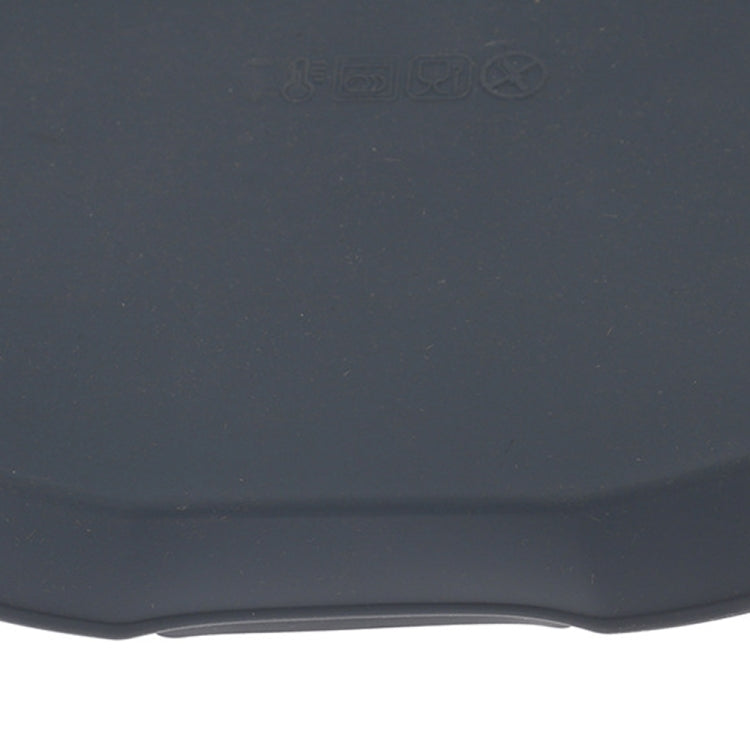 Heat-resistant silicone baking tray close-up, dark navy with embossed safety markings