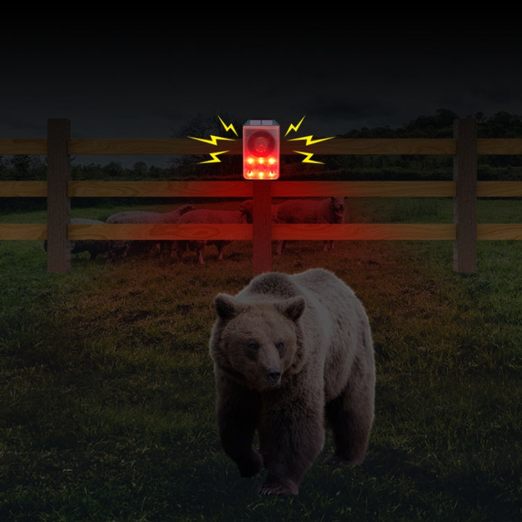 Outdoor solar infrared alarm on fence post with illuminated red warning light