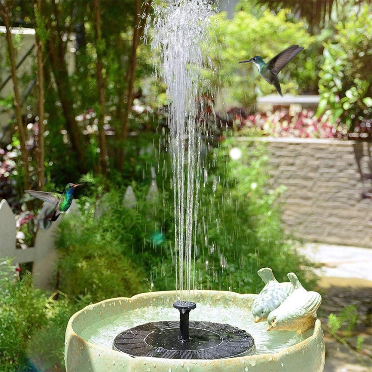 Black solar fountain insert on a bird bath with steady vertical water stream