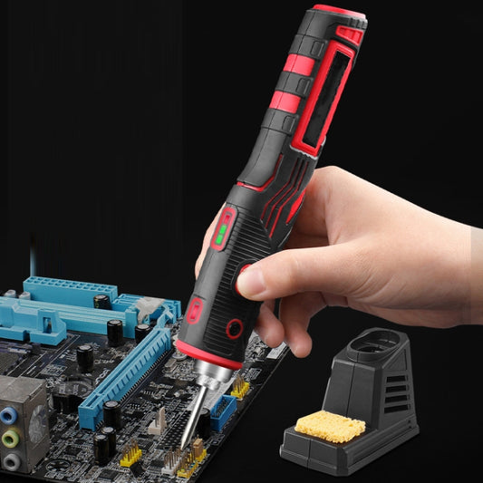 USB rechargeable soldering iron with metal tip, held over a circuit board and charging base