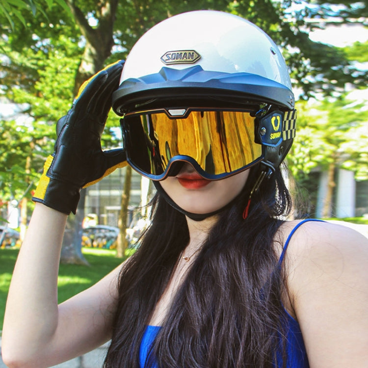 Motorcycle half helmet worn by rider, white shell with gold-tinted visor