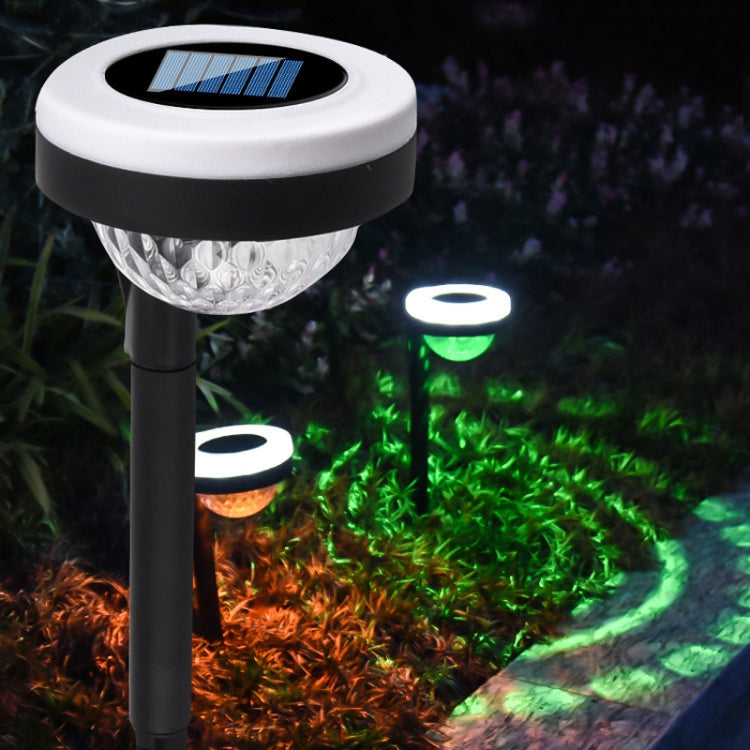 Outdoor solar LED ground plug lights with white solar tops glowing green and orange