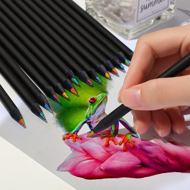 Hand holding black rainbow colored pencil drawing a colorful flower on paper