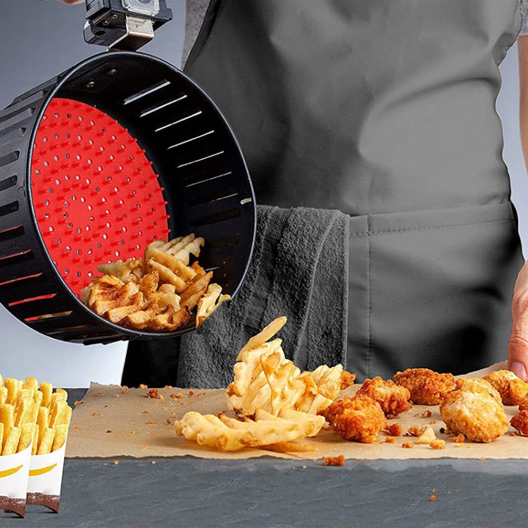 Red round silicone air fryer liner mat with raised perforations in the basket