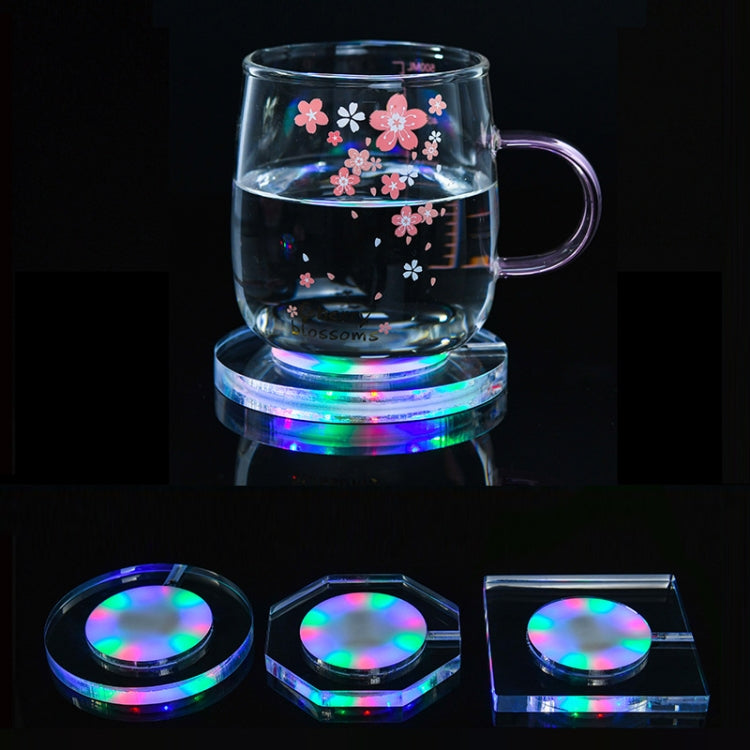 LED acrylic coaster with crystal base glowing under a clear mug with flower decals