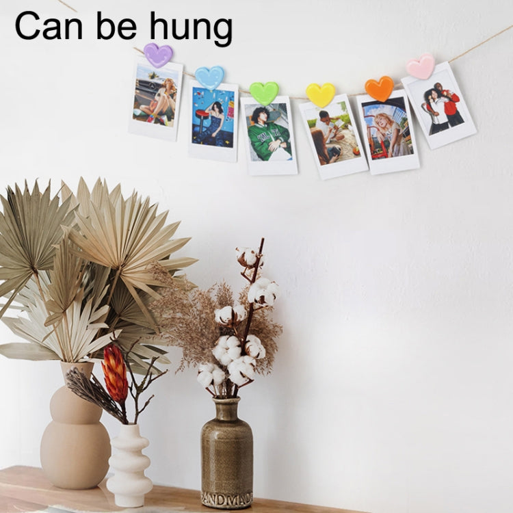 Heart-shaped photo clips holding multiple pictures, pastel colors on hanging cord