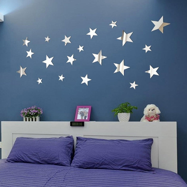 Silver star mirror wall stickers on a wall above a bed, decorative set