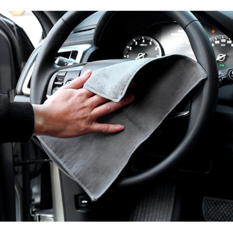 Gray car window cleaning towel held in a hand inside the car