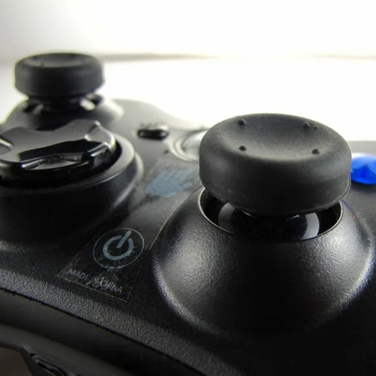 Black silicone joystick cap installed on a controller thumbstick, textured dome
