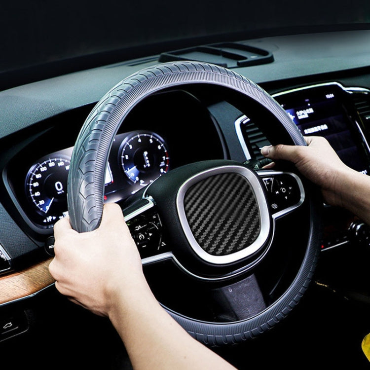 Blue-gray silicone steering wheel cover sleeve being fitted by hands