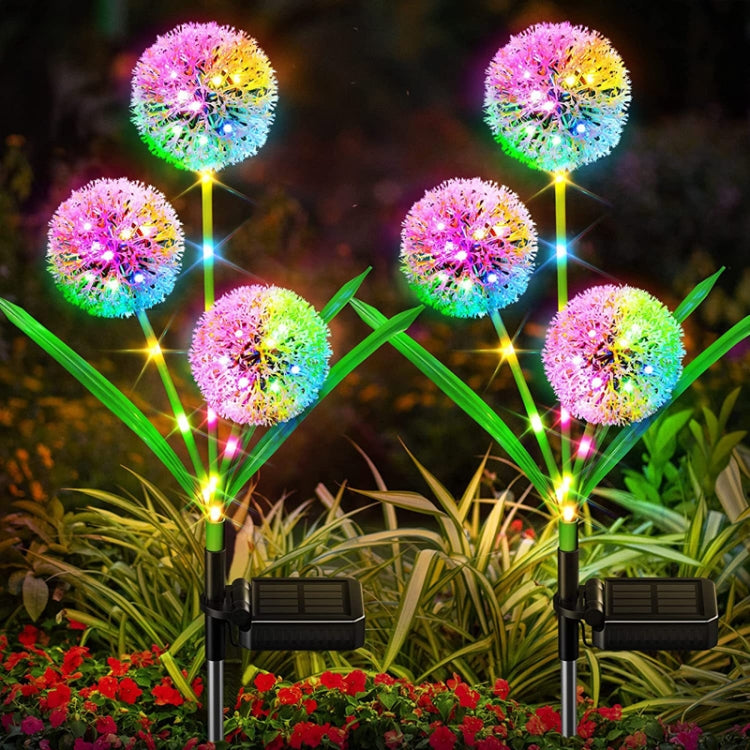 Solar LED dandelion ground plug lights with multicolor glowing flower heads in garden landscaping