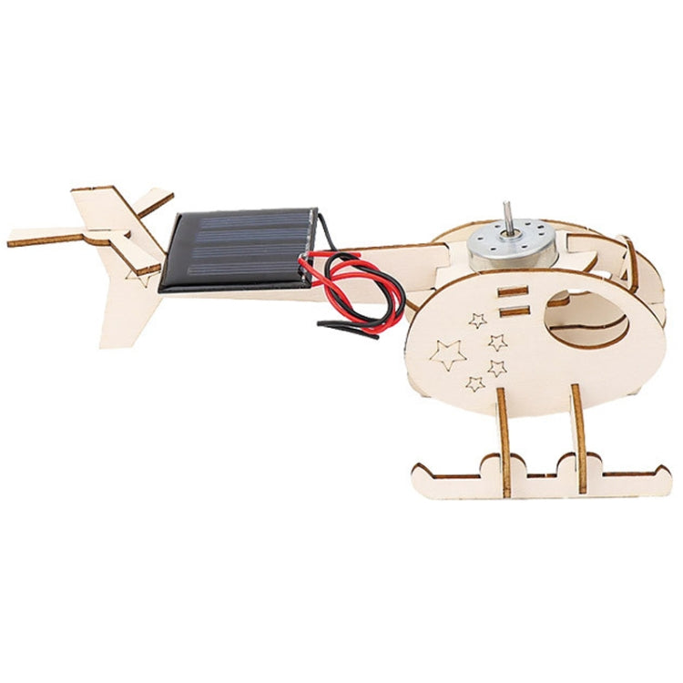 Assembled wooden helicopter model with solar panel, motor, and red/black wires