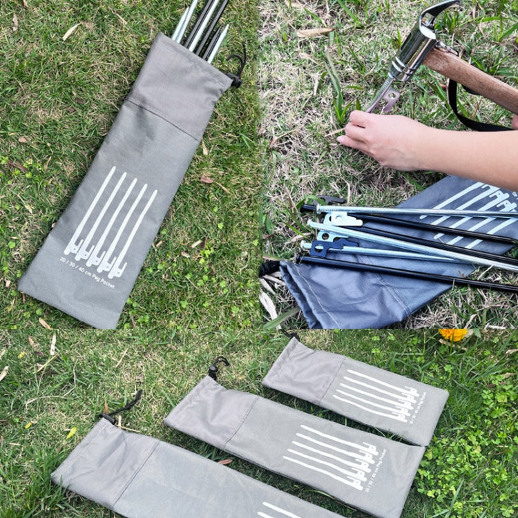 Gray drawstring ground spike storage bag with white graphic on grass