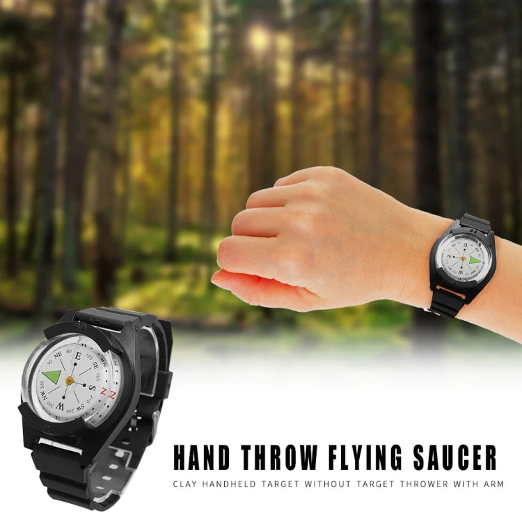 Black compass wristwatch on wrist with round dial and silicone strap, outdoor hand pose