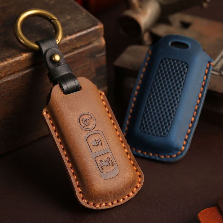 Brown and blue leather motorcycle key cases with gold rings, embossed buttons, stitched edges.