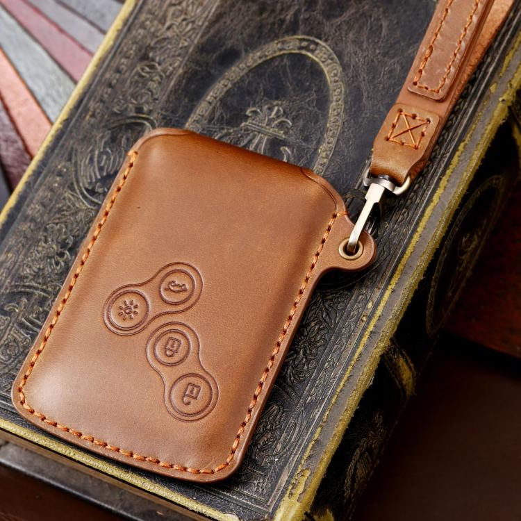 Brown leather car key protective cover with embossed button icons and keyring ring