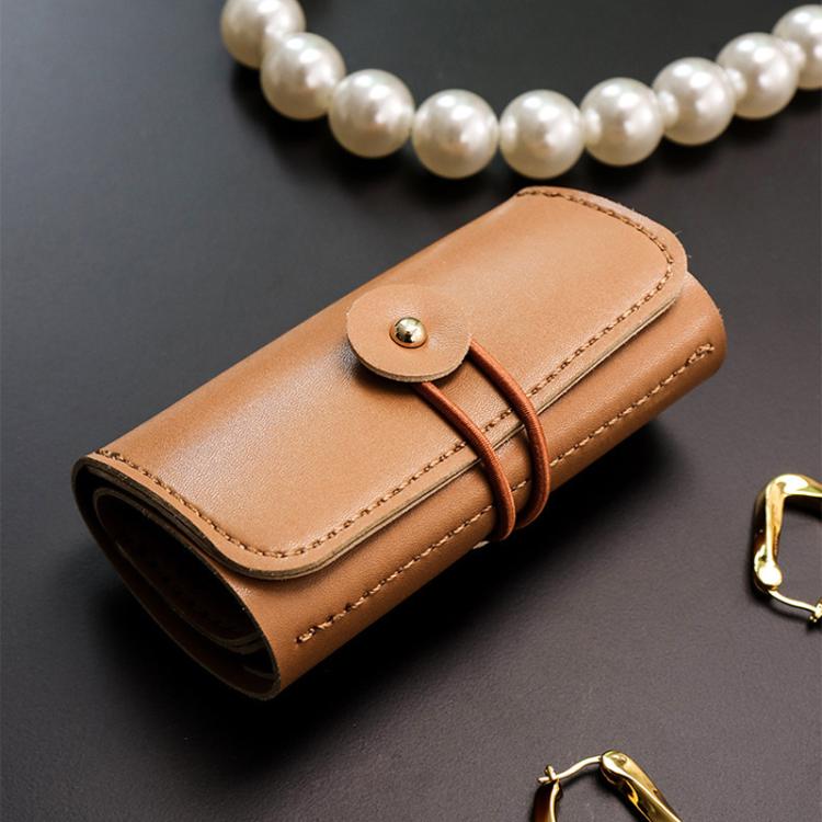 PU leather-style jewelry roll with snap closure and wrap strap, tan-brown