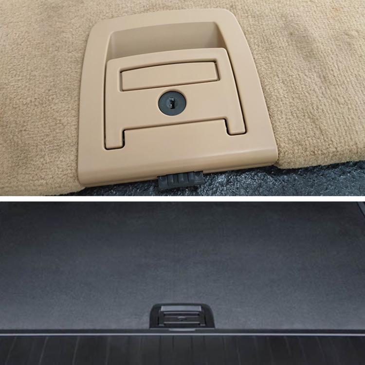 Beige trunk lid handle cover with lock hole mounted on car interior panel