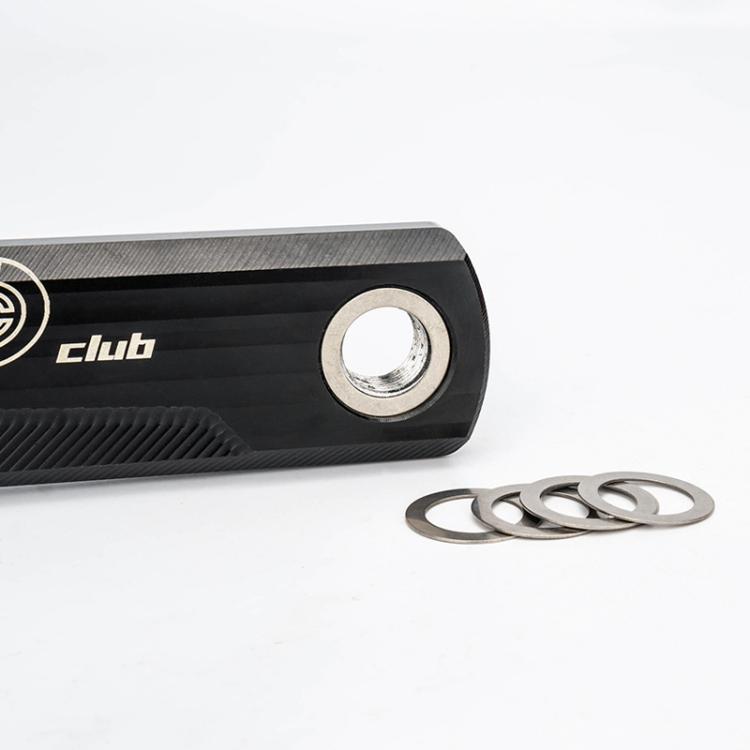 Stainless steel washer gaskets next to a bicycle pedal axle and mounting hardware