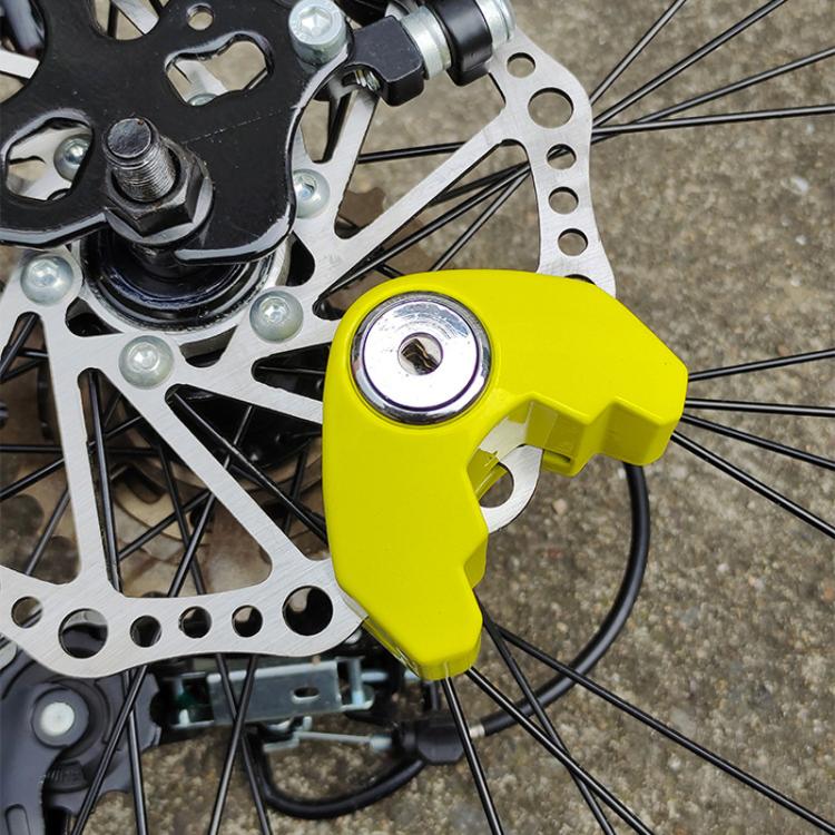 Universal disc brake lock, yellow lock attached to bicycle disc rotor and spokes