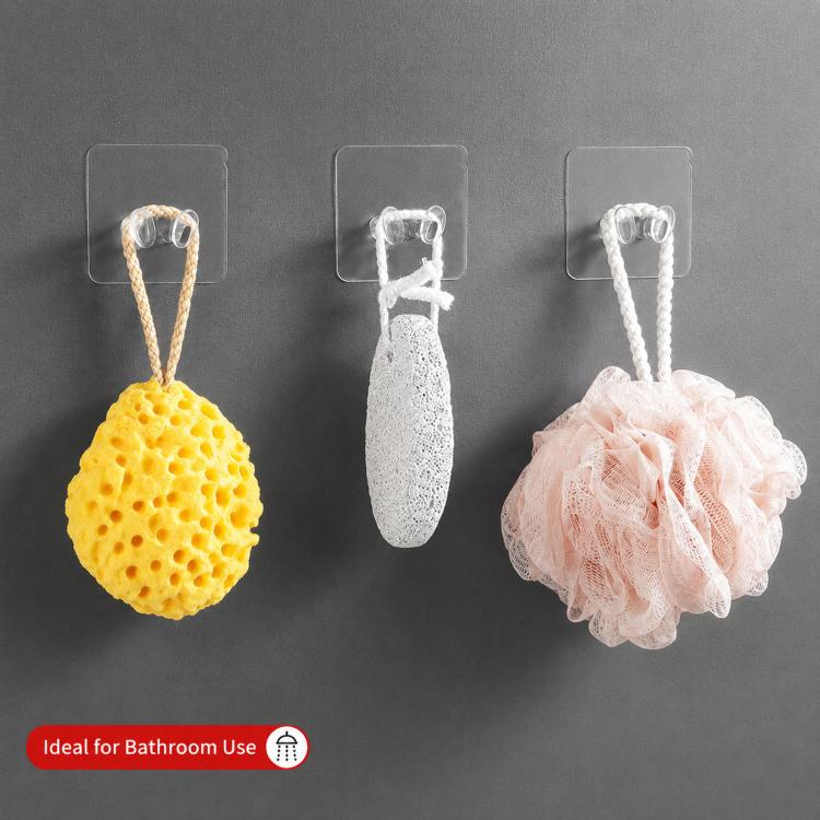 Adhesive wall hooks holding sponges with clear clips and transparent square backing pads