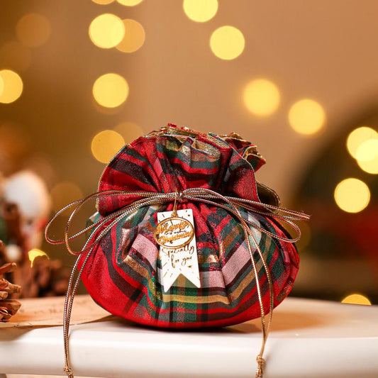 Small Christmas plaid drawstring pouch in red, green, and dark stripes with gold gift tag and bow.
