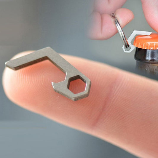 Mini bottle opener keyring tool, gray metal cap lifter held in hand