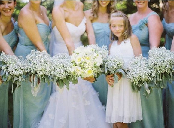 Artificial baby's breath wedding bouquets held by women and a child, white blooms