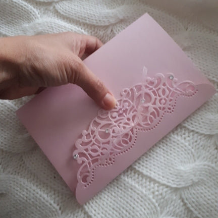 Ornate floral metal cutting stencil held on a card, scalloped decorative border