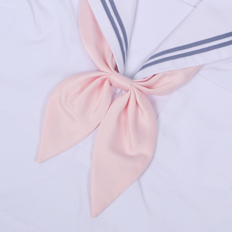 Goldfish-knot bow tie in light pink with a centered knot on a white shirt collar.
