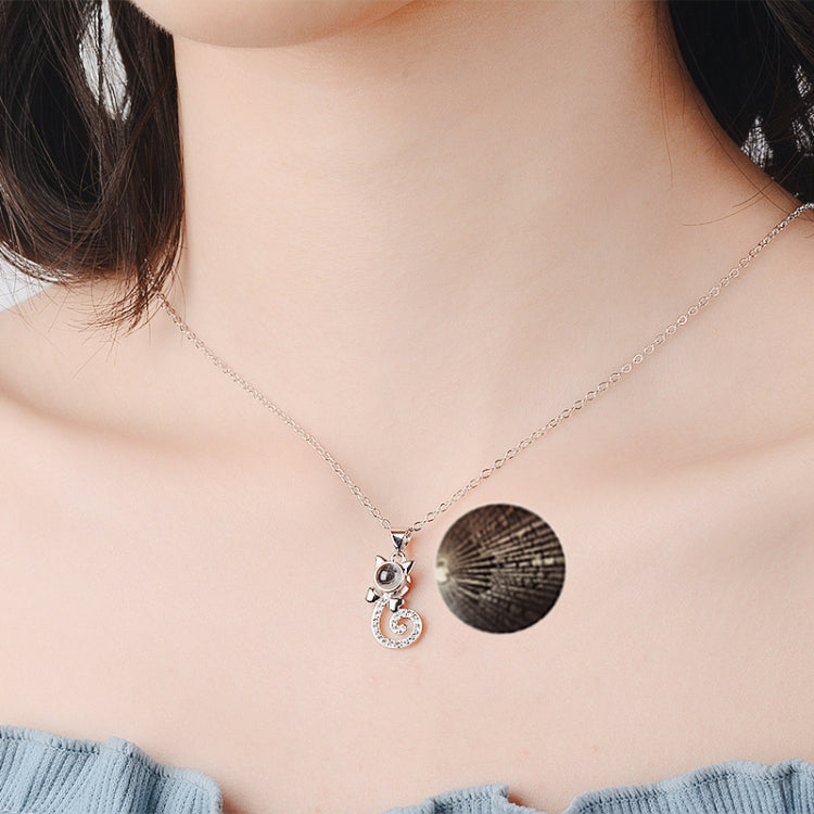 White copper projection pendant necklace with round disc and heart swirl charm, crystal accents