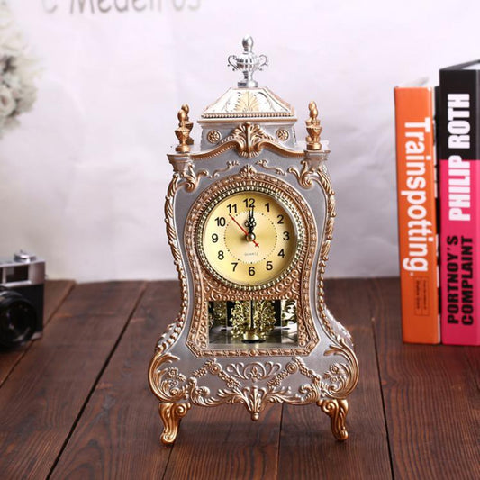 Decorative pendulum clock with ornate gold-tone frame and white dial on legs