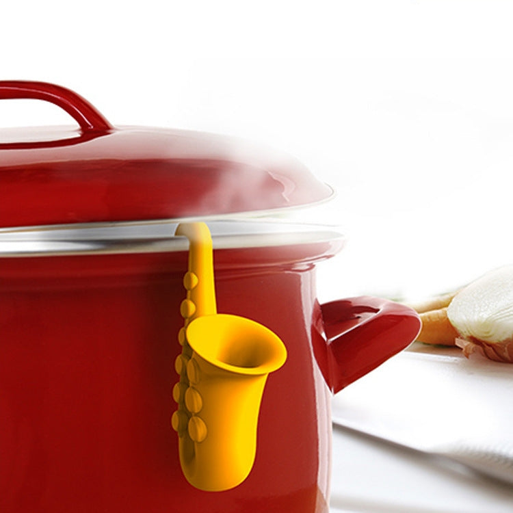 Yellow horn-shaped silicone anti-overflow pot lid insert on red pot