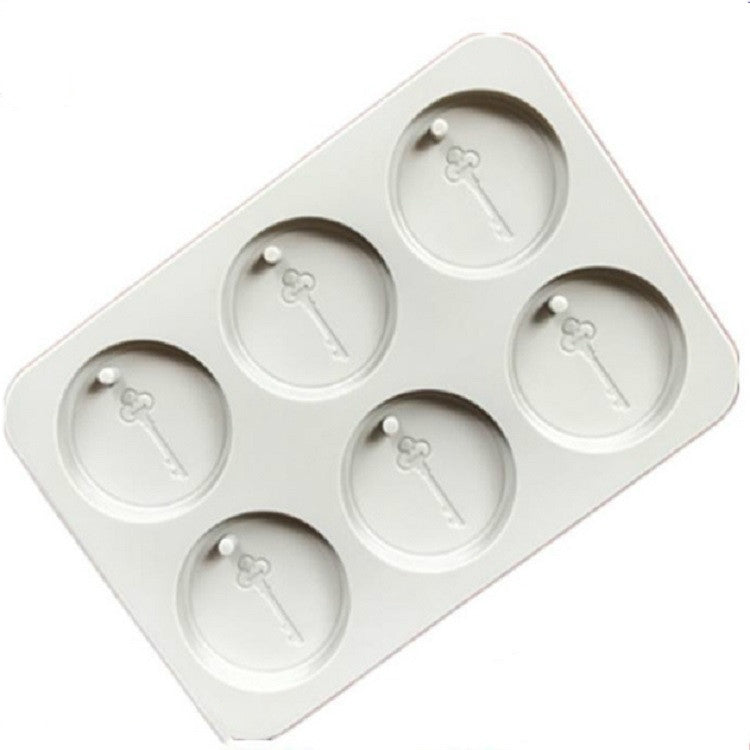 White silicone mold tray with six round cavities and small key-shaped embossed details