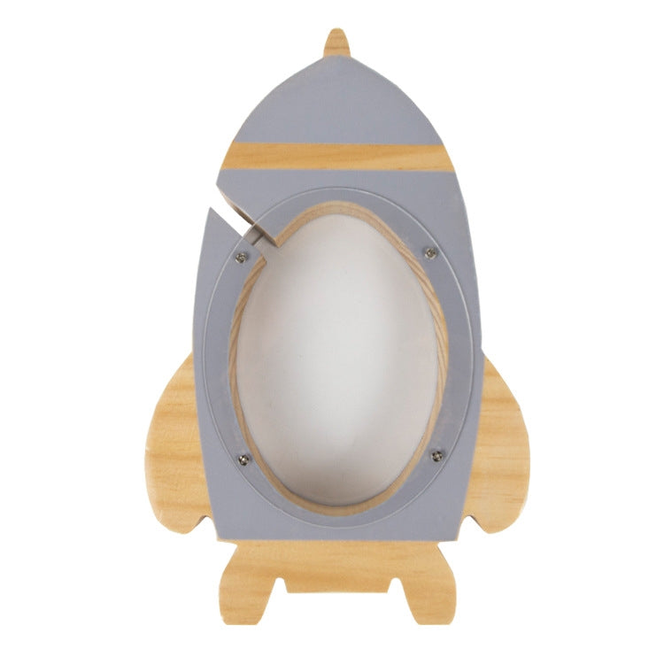 Light grey rocket money box with oval coin slot and wooden base