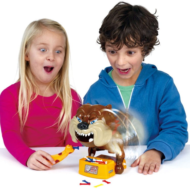 Toy dog biting hand game with orange base and accessories on table