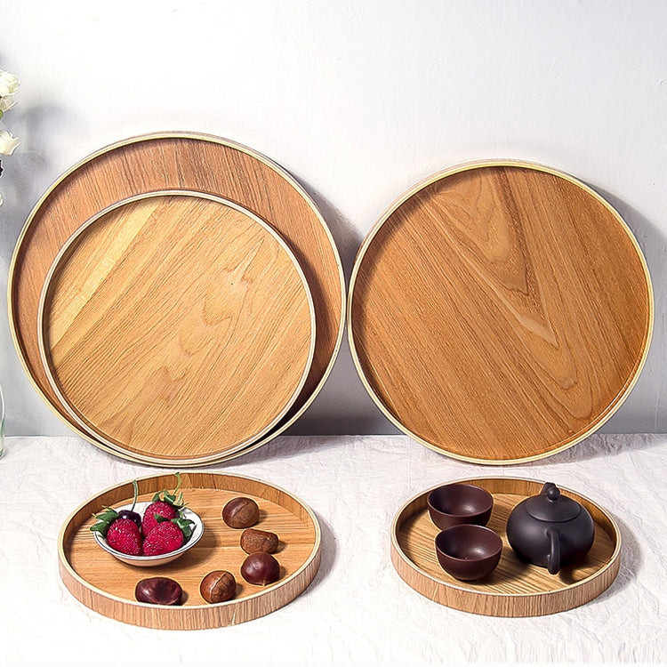 Two round wooden tea trays with nested design; one tray holds strawberries and small cups.