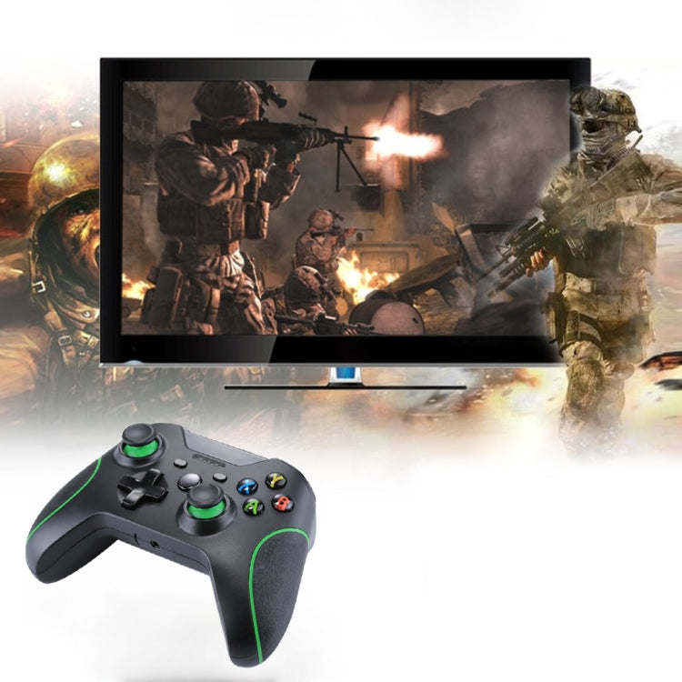 Black wired game controller with green trim, front-left view with analog sticks and face buttons