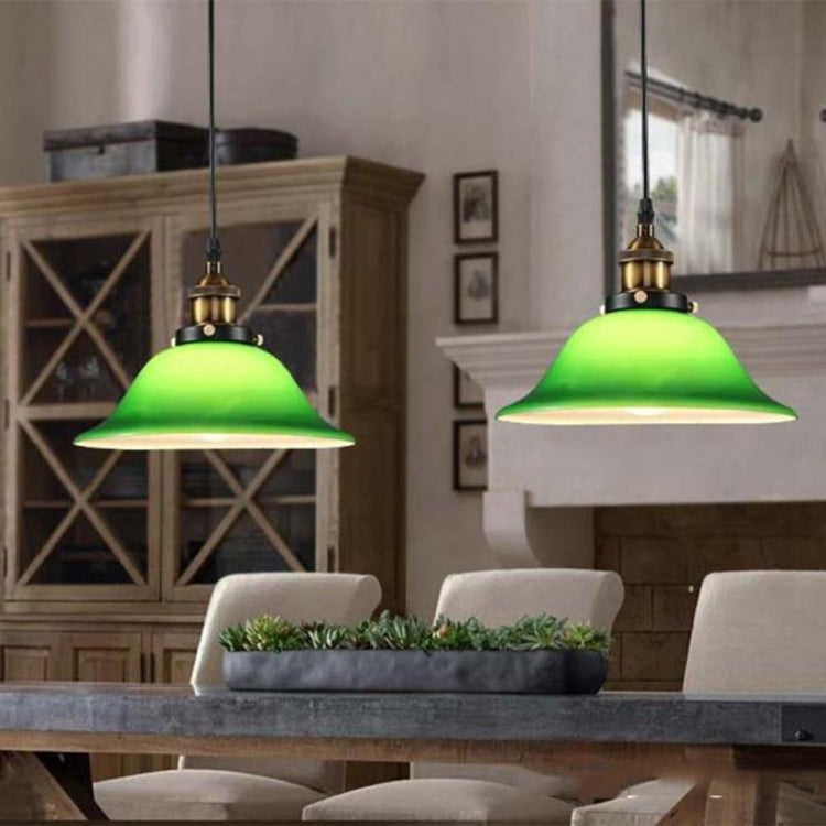 Green glass pendant lamp with antique gold top and warm Edison-style bulb, hanging