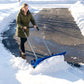 Blue wheeled snow shovel with wide curved blade and long silver handles