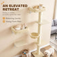 Beige wall-mounted cat tree with elevated platforms, hammock bed, and tall base scratching post