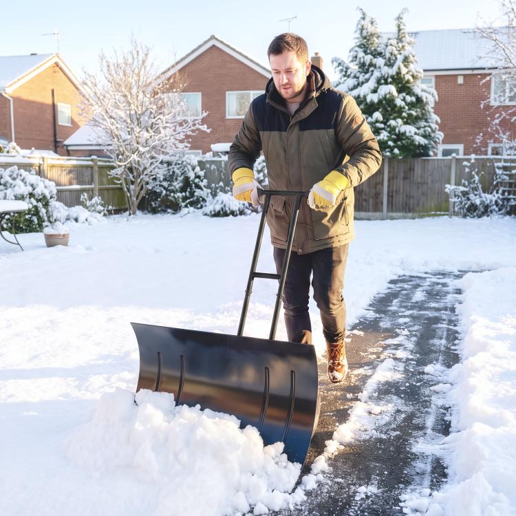 Wheeled snow shovel pushing snow with black metal blade and red wheels