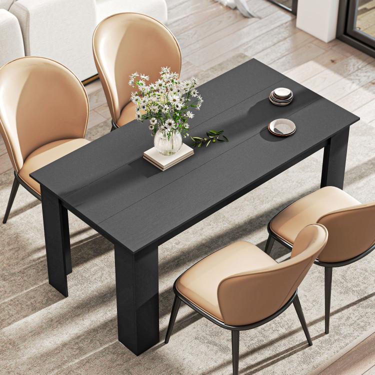 Black rectangular dining table with a floral centerpiece and four upholstered chairs