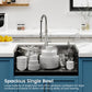 Black single-bowl overmount sink with faucet and stacks of dishes inside