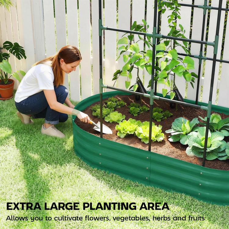 Green metal raised garden bed with arched trellis, person planting seedlings along the edge