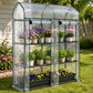 Clear 3-tier mini greenhouse with green frame, roll-up doors, and plant pots on shelves