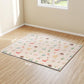 Foldable baby play mat on hardwood floor, light cream woodland animal print with border