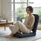 Grey padded floor chair with contoured backrest and seat for reading or gaming